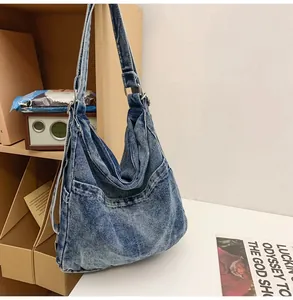 Detail van de vintage gewassen denim tote bag met metalen gespen en zijvakken