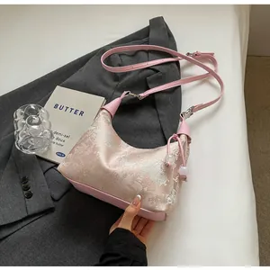 Detail of pink embroidered jacquard hobo bag with adjustable strap and bead drawstring