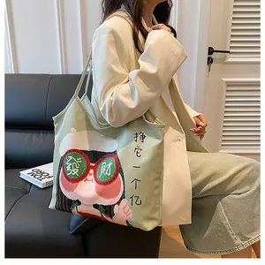 Detailed view of green canvas tote bag with original cartoon print and Chinese characters