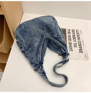 Detail van de blauwe gewassen denim hobo tas met zilveren ringen en getextureerde stof
