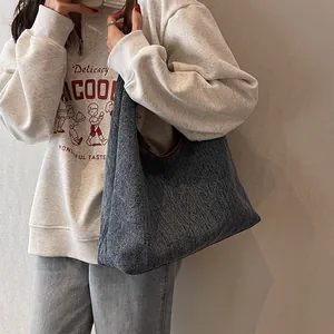 Chic blue-gray denim tote bag for women shown with a casual white sweatshirt outfit
