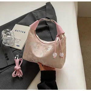 Detailed close-up of pink jacquard handbag with silver Chinese embroidery and leather strap