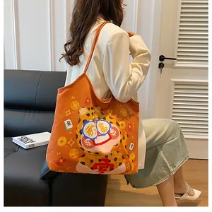 Detail of orange canvas tote bag with cute cartoon leopard and fortune illustrations