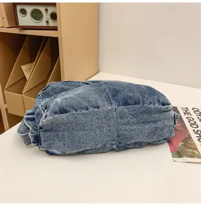 Detail van blauwe denim tas met metalen gesp en hoogwaardige stikseltextuur voor een casual look