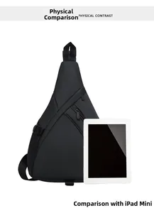 Detailed size comparison of black crossbody chest bag next to an iPad mini for scale