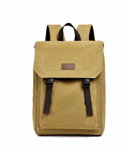 Detail view of mustard yellow canvas backpack featuring leather patch and dark brown straps