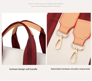 Close-up of canvas tote featuring striped handles and detachable gold hardware details