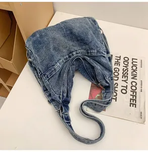 Platliggende weergave van grote gewassen denim shopper met metalen ringen en decor
