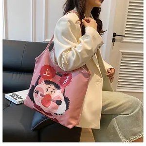 Detailed view of pink canvas tote bag with original cartoon illustration and strap design