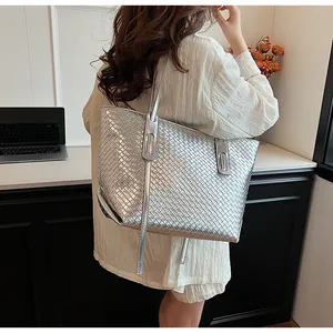 Dettaglio macro della borsa tote intrecciata argento metallizzato con trama della pelle