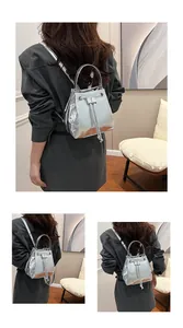 Detail view of silver metallic bucket backpack with drawstring and sturdy top handle
