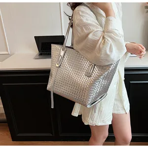 Dettaglio della borsa tote intrecciata argento con texture metallica e spalline