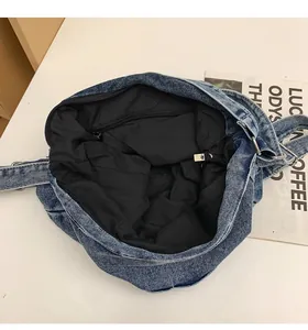 Detailopname van de binnenkant van een blauwe denim tas met voering en ritszak