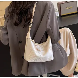 Detailed close-up of beige oriental embroidery bag with floral patterns on a model