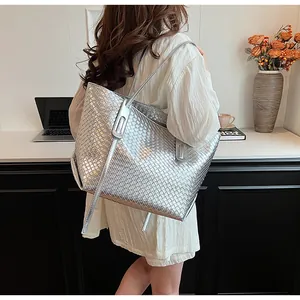Dettaglio della borsa shopper intrecciata argento con tracolla in un ambiente da ufficio