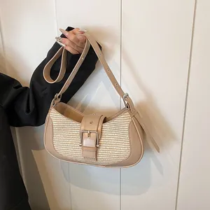 Detail of beige leather and woven straw shoulder bag with adjustable metal eyelet strap