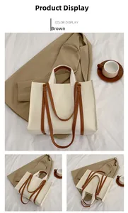 Vue détaillée du grand sac fourre-tout en toile avec anses en cuir marron sur tissu blanc