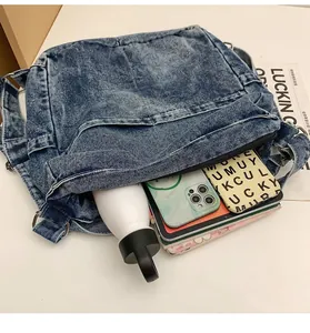 Bovenaanzicht van grote denim draagtas met opbergruimte voor een waterfles en een tablet