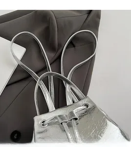 Detail of silver metallic backpack showing smooth shoulder straps and drawstring closure
