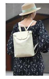 Rear view of model wearing a beige quilted backpack with elegant diamond patterns