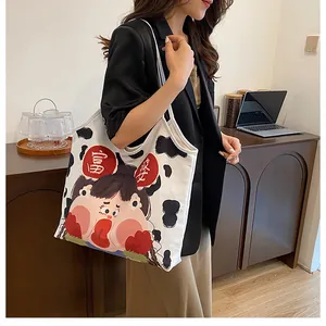 Detail of a cow print canvas tote bag featuring a cute cartoon girl and artistic text