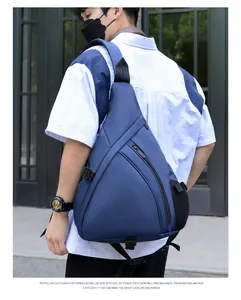 Outdoor lifestyle shot of a navy blue nylon triangle sling bag with mesh side pocket