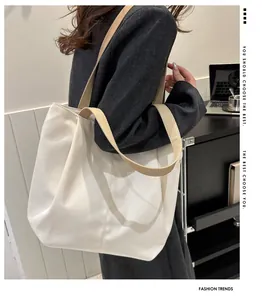 Side view of model wearing a spacious white canvas tote bag with beige handles