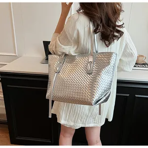 Dettaglio della borsa tote intrecciata argento metallizzato indossata da una modella