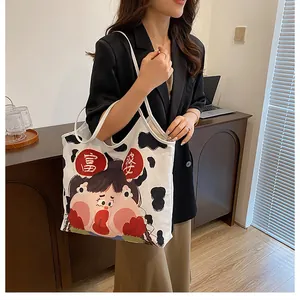 Detail of canvas tote bag with cow print and cartoon illustration of a girl