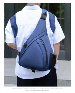 Rear view of dark blue triangle sling bag with mesh side pocket and zipper on man