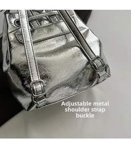Detail of silver metallic crinkled backpack showing adjustable shoulder strap hardware
