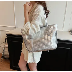 Dettaglio di una borsa tote intrecciata argento con finitura metallica e tracolla sottile