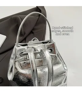 Detail of silver metallic backpack showing smooth stitching and hand-pressed edges texture