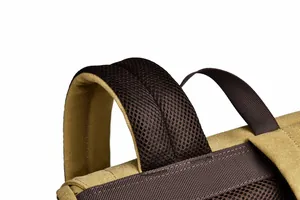 Close-up of khaki canvas backpack featuring breathable mesh shoulder straps and handle