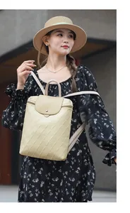 Detail of beige quilted leather backpack with elegant top handle and metal flap closure