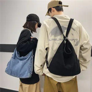 Minimalistische denim draagtas en zwarte canvas rugzak getoond op modellen in beeld