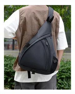 Outdoor lifestyle view of a black nylon crossbody sling bag with adjustable strap and buckle
