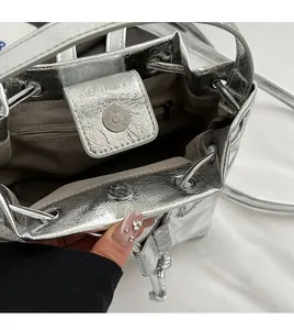 Silver backpack interior with metallic crackle finish, drawstring closure, and magnetic snap