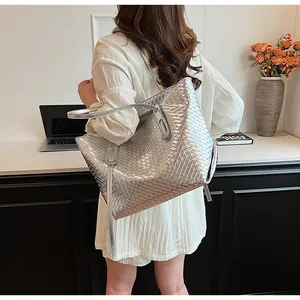 Dettaglio della trama della borsa tote intrecciata argento e della tracolla lunga