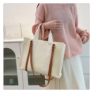 Vue détaillée du grand sac fourre-tout en toile avec anses en cuir marron sur mannequin