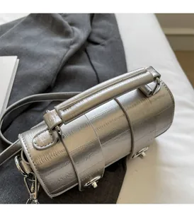 Détail de la poignée renforcée et du sac cylindrique argenté métallisé avec plis élégants