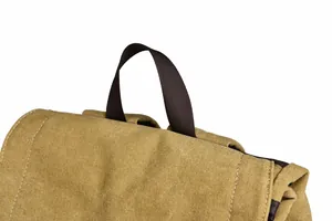 Close-up of durable khaki canvas backpack showing reinforced brown nylon handle stitching