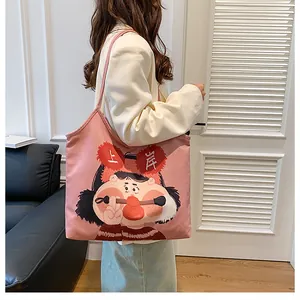 Detail of pink canvas tote bag featuring cute cartoon girl print and shoulder strap