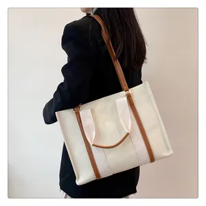 Sac cabas en toile avec garniture en cuir, bandoulière et vue latérale sur un modèle