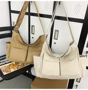 Detail of large canvas crossbody bags with dual pockets in khaki and beige colors