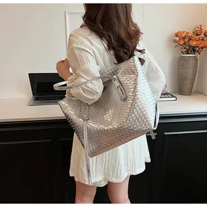 Dettaglio di una borsa tote intrecciata argento con texture metallica in un ufficio