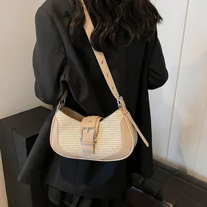 Detail view of woven shoulder bag with adjustable leather strap worn with a blazer