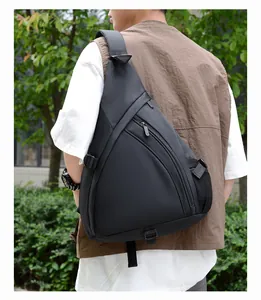 Detail of black triangular chest bag with multi-zipper pockets and mesh side pouch