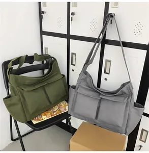 Detail of military green and dark grey canvas messenger bags with multiple pockets