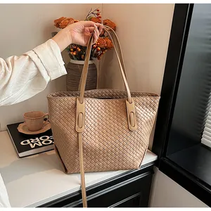 Dettaglio della borsa tote intrecciata kaki con texture e design a doppio manico